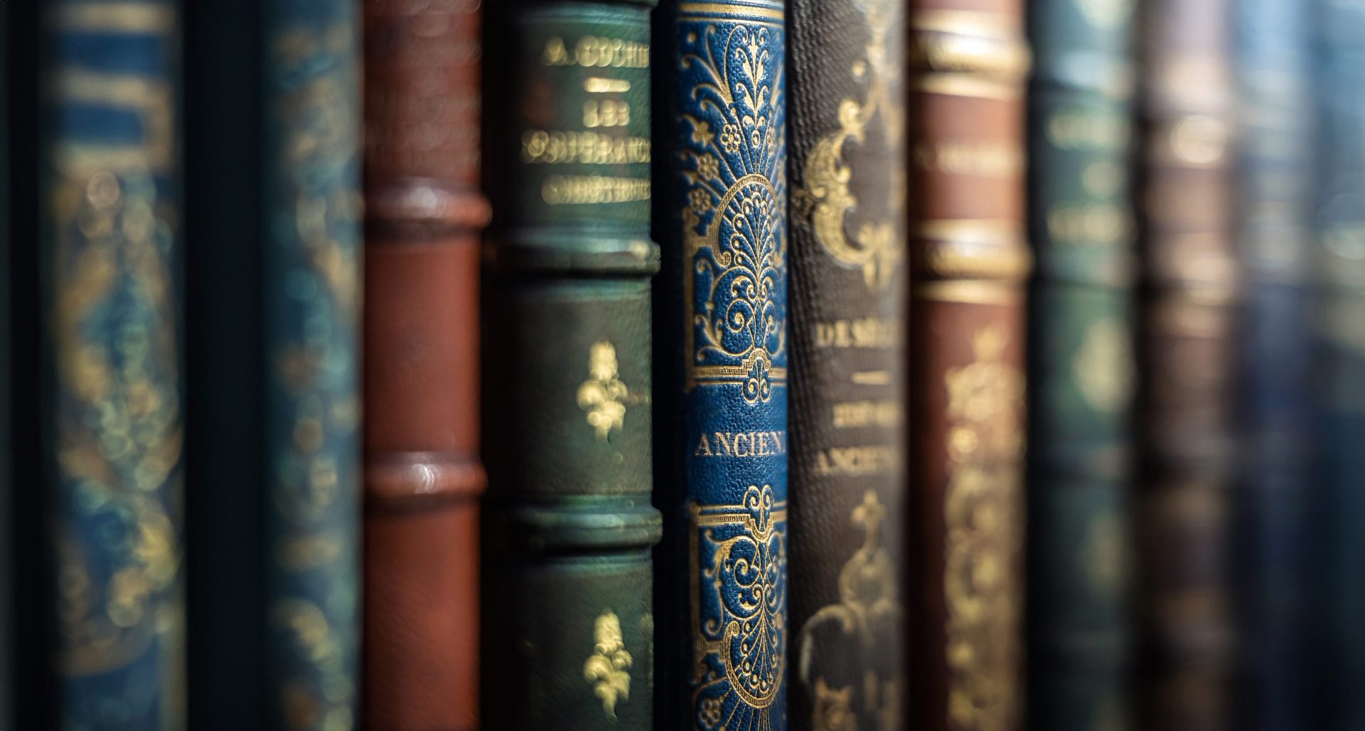 Close up of Victorian-era books on a bookshelf. One of the books is an emerald green colour, which indicates that it could be toxic.