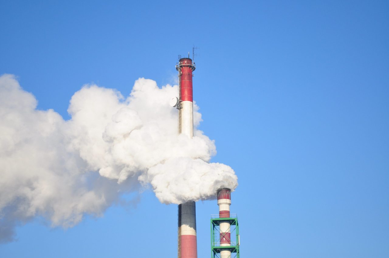 image showing steam and emissions coming from a factory tower