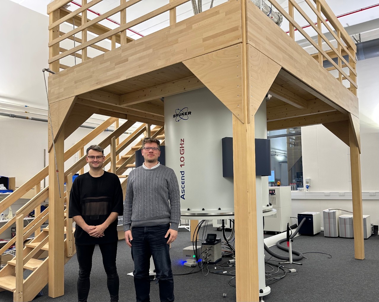 Dr Dominik J. Kubicki and Dr Benjamin Gallant in front of the Bruker flagship 1 GHz solid-state NMR system in the UK High-Field Solid-State NMR Facility at Warwick