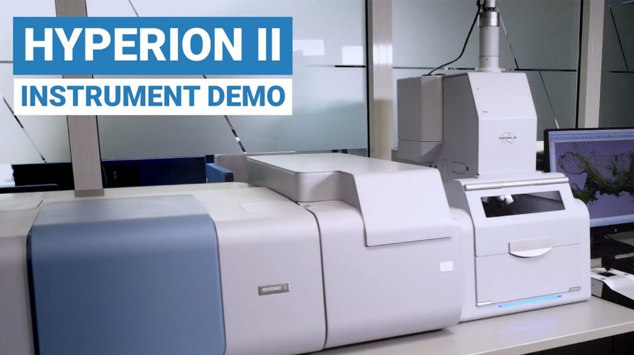 Image showing LUMOS FT-IR microscope and hands pointing at it. Big captions explain to click this image to request and on-demand demo video