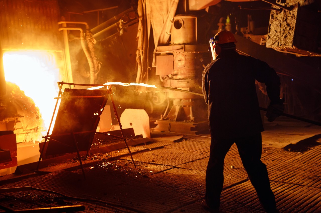 Steelworker taking a slag sample for analysis from the blast furnace.
