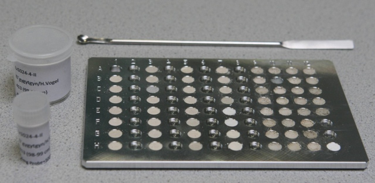 Image displays a microplate with 96 wells loaded with soil samples.