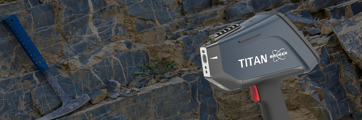 Rock characterization for mining and exploration with portable mineral analyzers. Image shows a surface of sheet rock in a mine with a pickaxe and the TITAN XRF gun. 