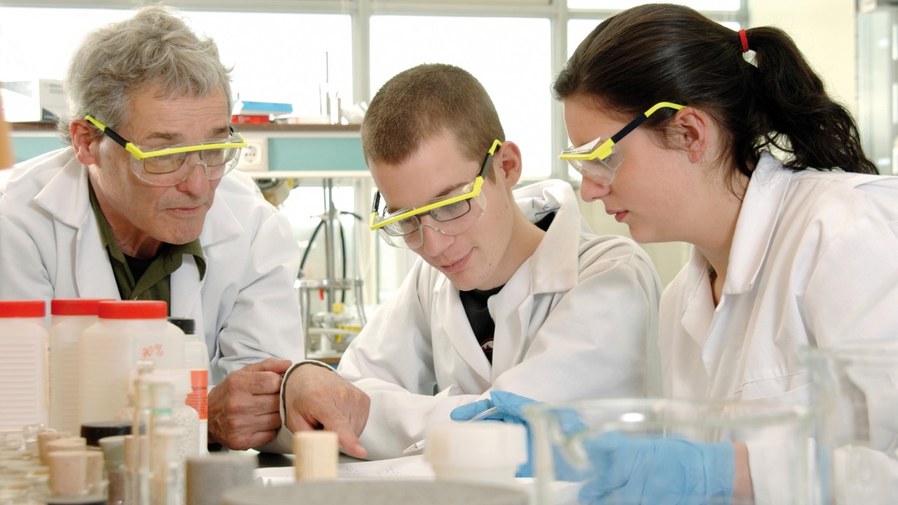 Profesor con estudiantes en un laboratorio.