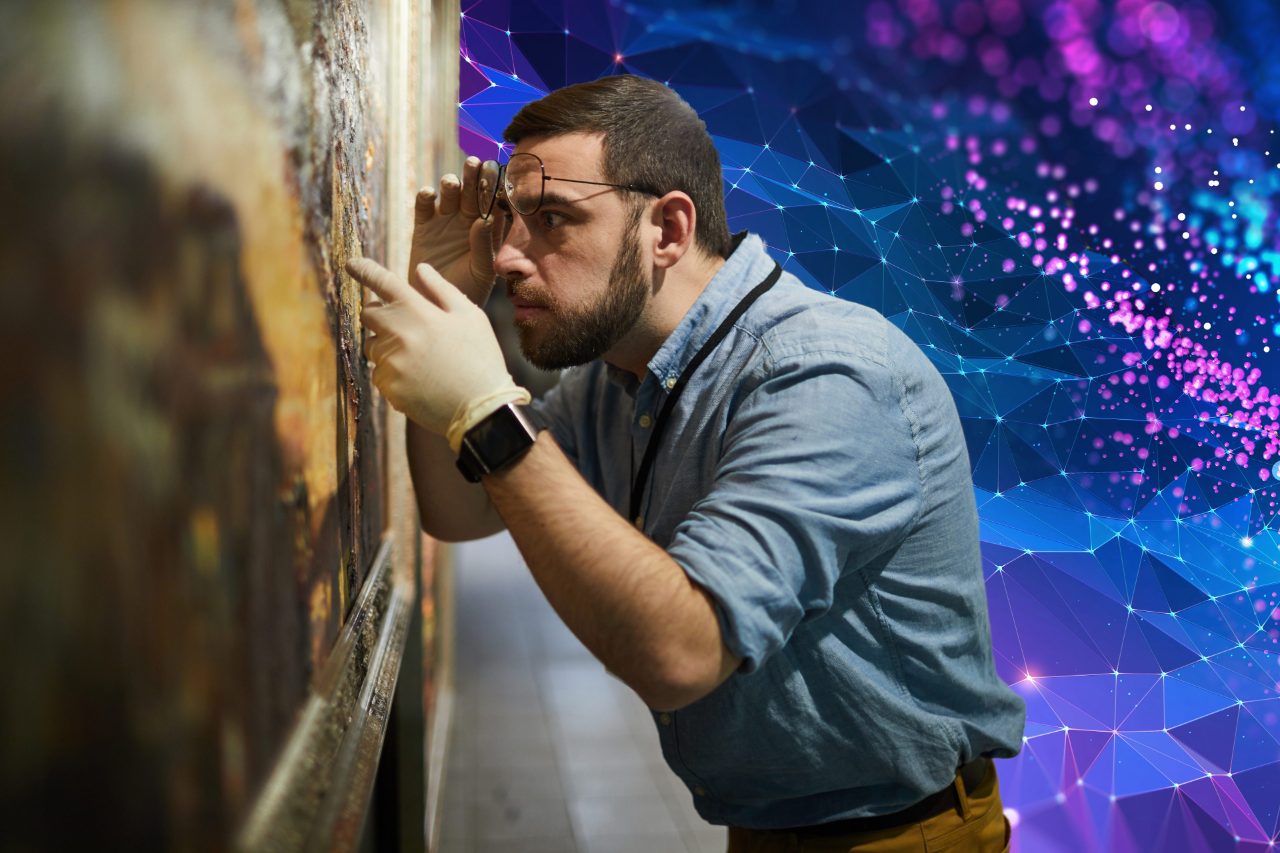 Side view waist up portrait of bearded museum worker inspecting painting for restoration