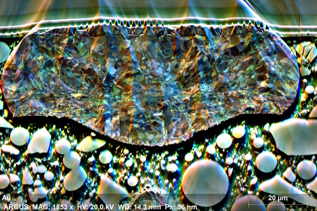 Orientation contrast image acquired with ARGUS imaging detector. It reveals the microstructure, and despite some curtaining induced by ion milling, the sample is well prepared; internal strain in the gold bond is clearly visible by ARGUSTM color-coded orientation contrast.