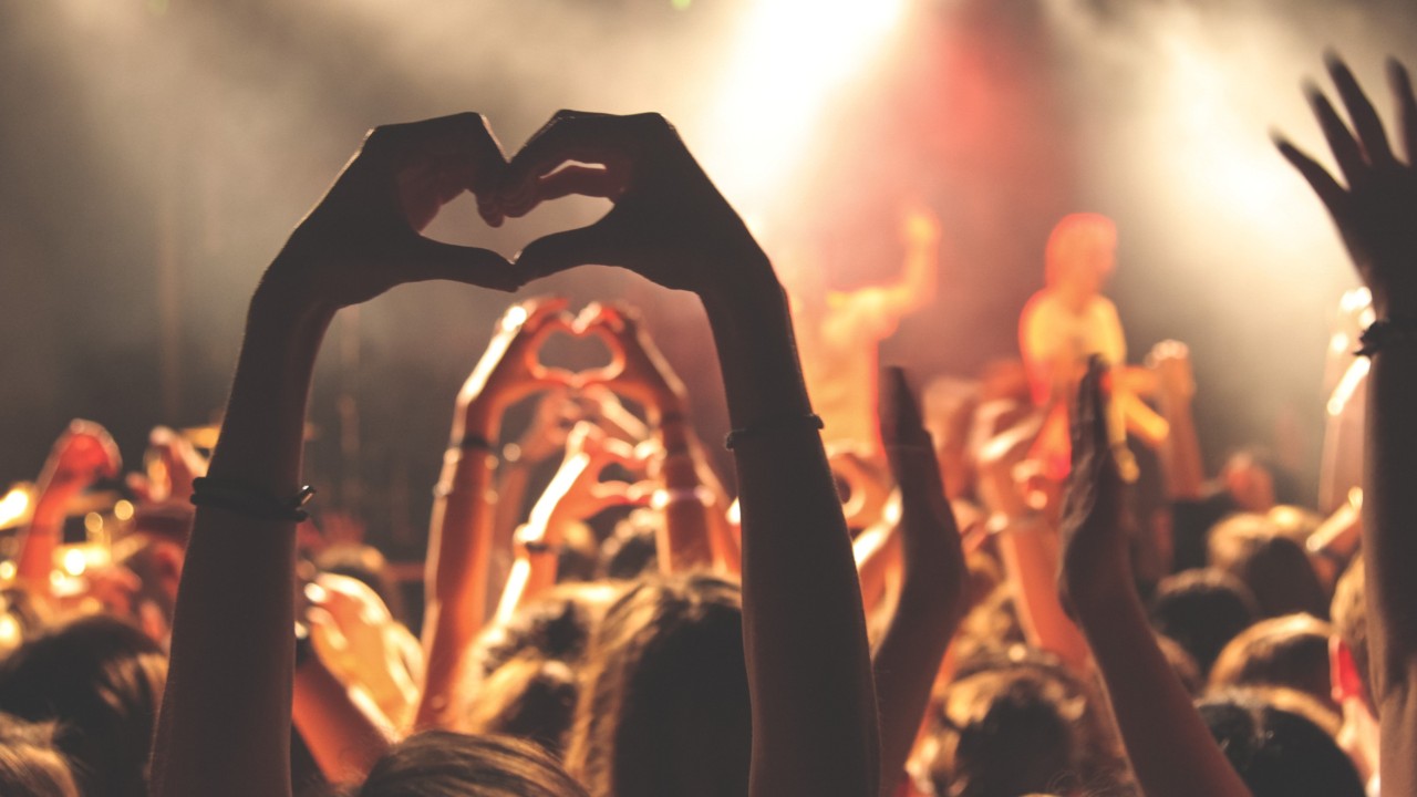 Concert-goers forming a heart shape with their hands.