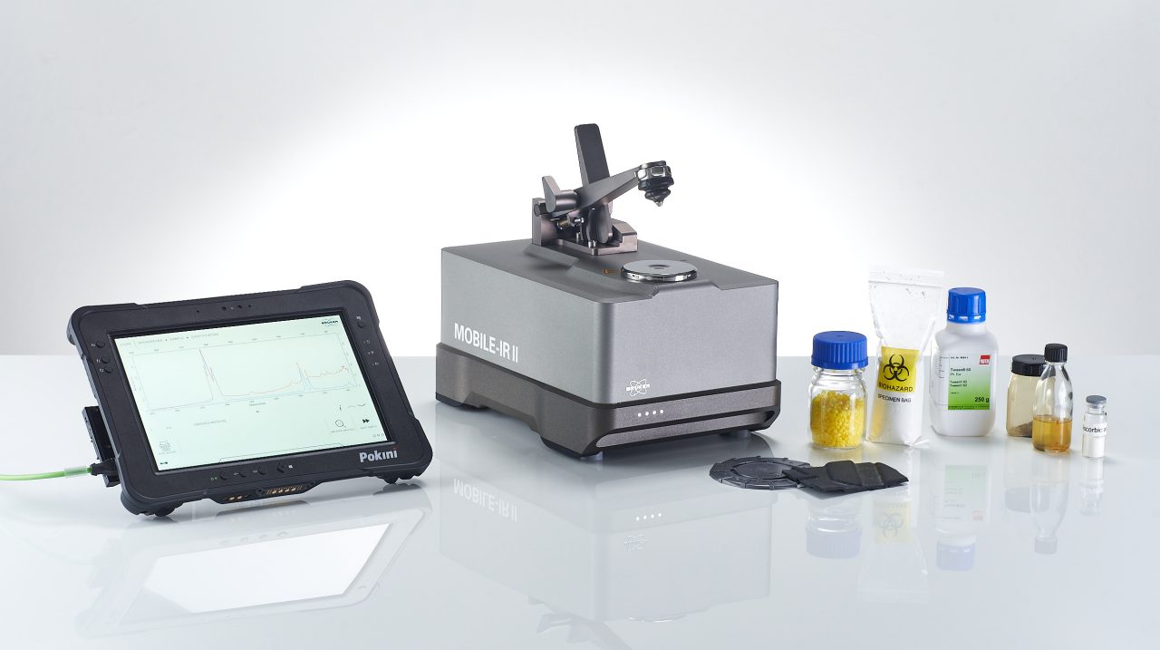 Mobile FT-IR spectrometer surrounded by different sample types and the tablet PC showing a successfull FT-IR measurement.