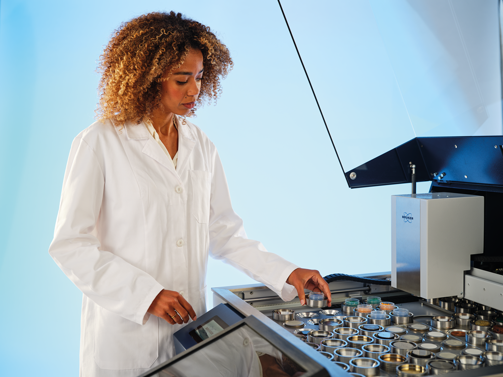 Image shows a woman operating and loading samples into the S8 TIGER XRF spectrometer 