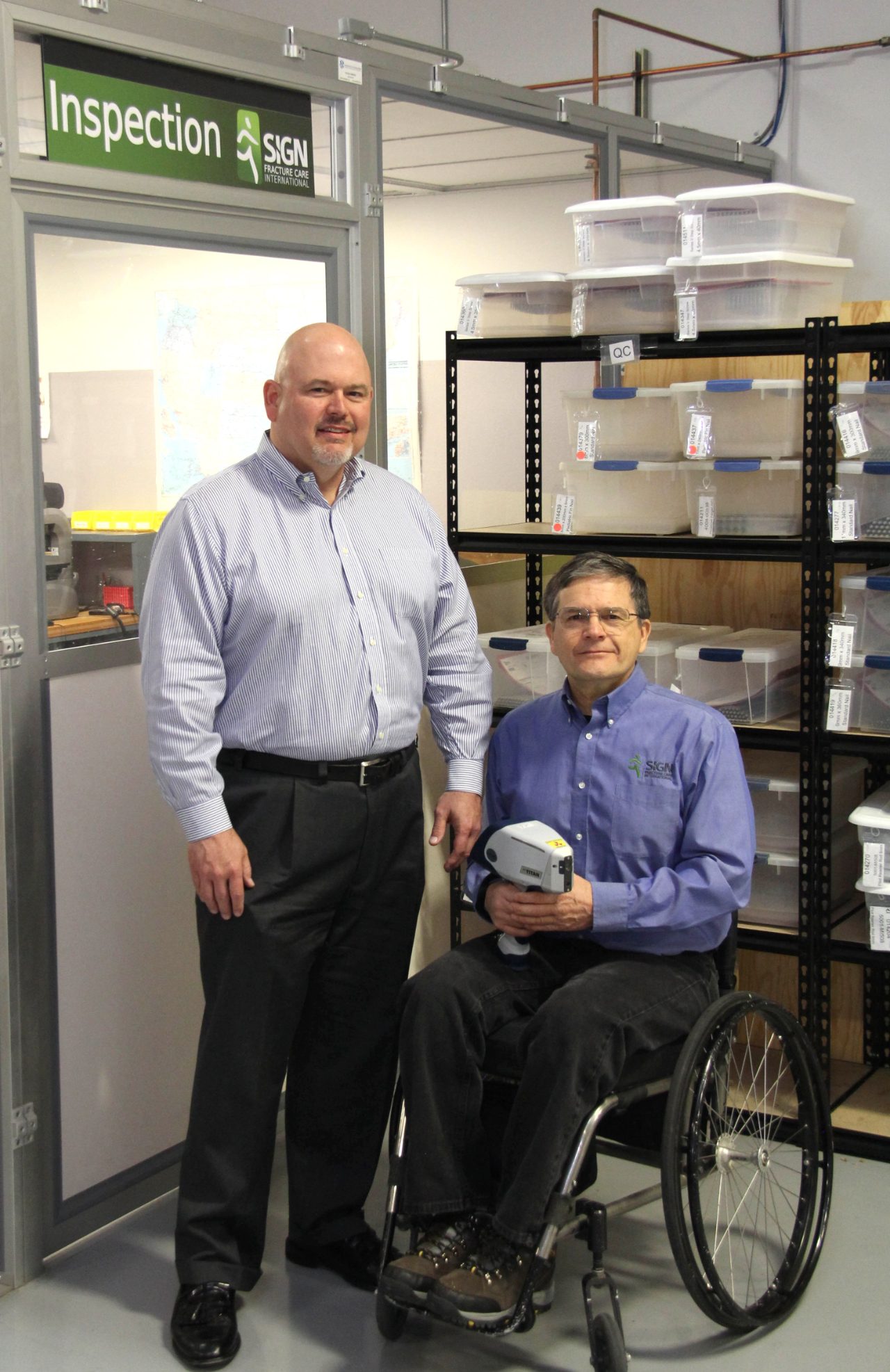 Jerry Sooter (left), Marketing Manager of Bruker Nano Analytics' HMP business unit, presenting a S1 TITAN handheld XRF alloy analyzer to Richard Grizzell (right), SIGN Fracture Care International.