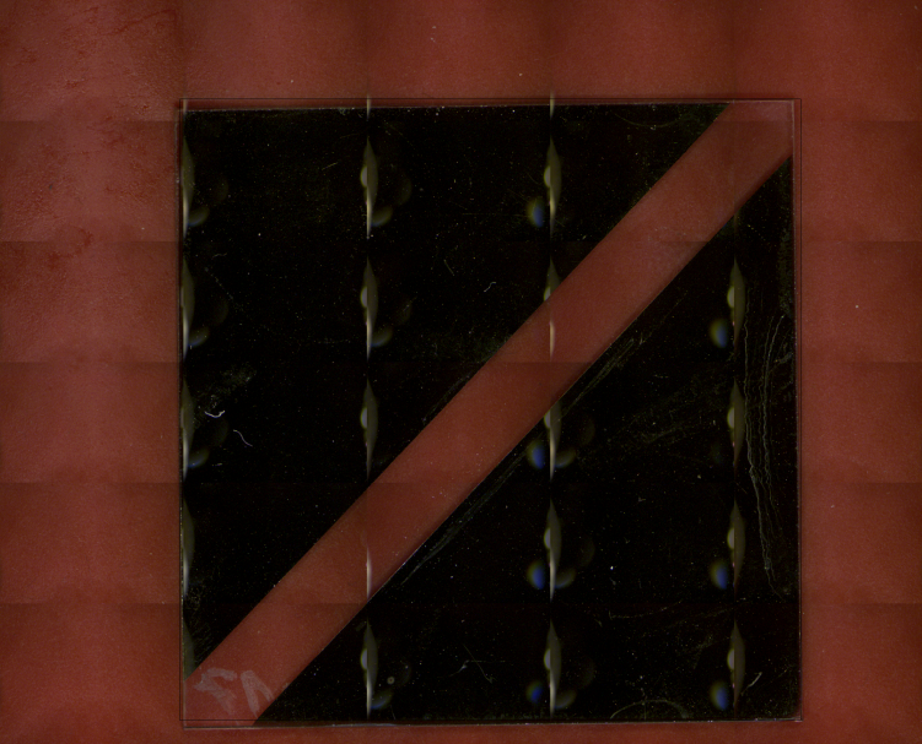 The sample, two electrodes on a glass substrate, is a test device for photoinduced electrolysis.  It is composed of a bi-metal monolayer with a concentration gradient along the surface. The glass substrate is coated by magnetron sputtering of a dual Cu-Al-target.