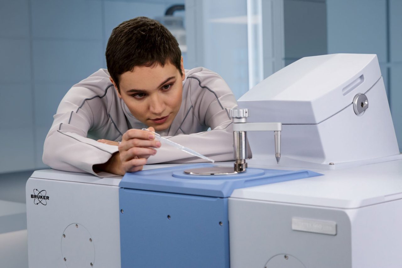 A woman drips a liquid from a pipette onto the sample tray of the VERTEX NEO Ultra.