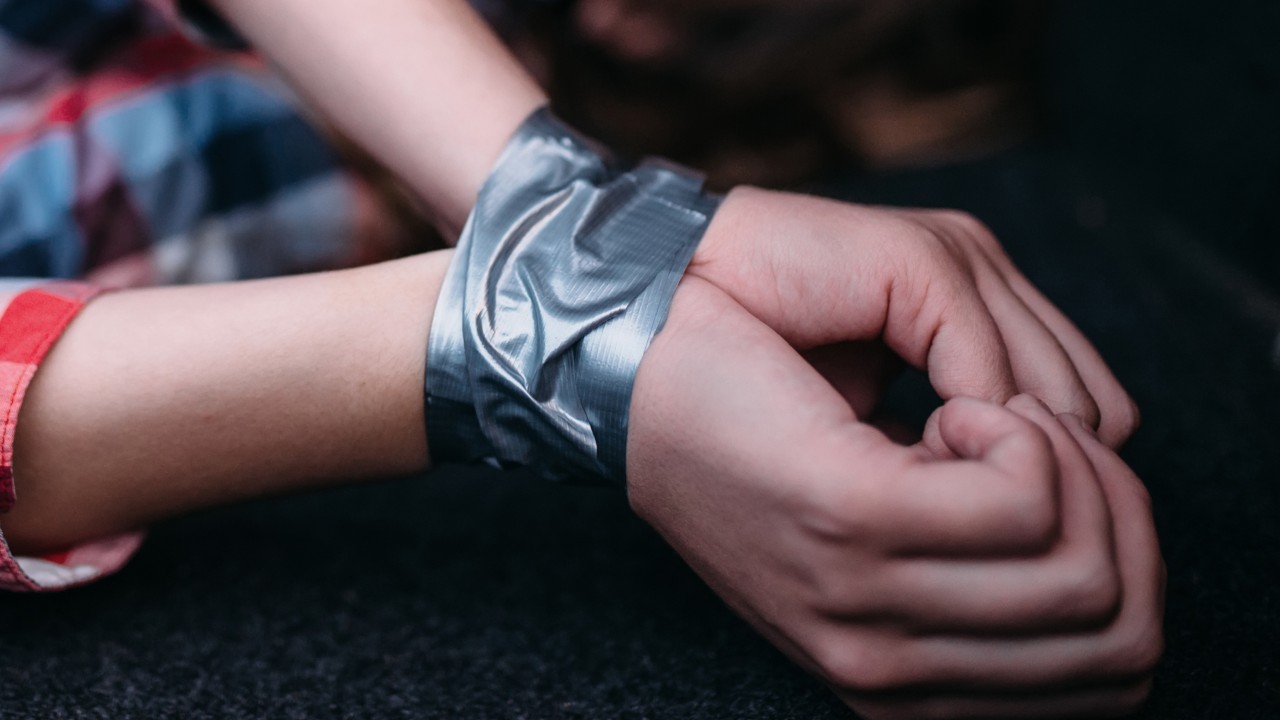 Hands are secured with adhesive tape.