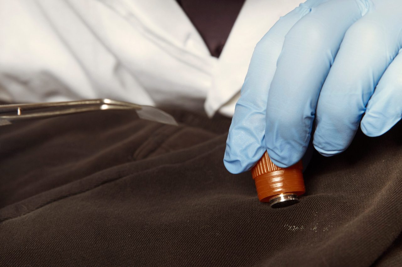 Forensic scientists examine a piece of clothing for traces. Gunshot residue analysis with XRD