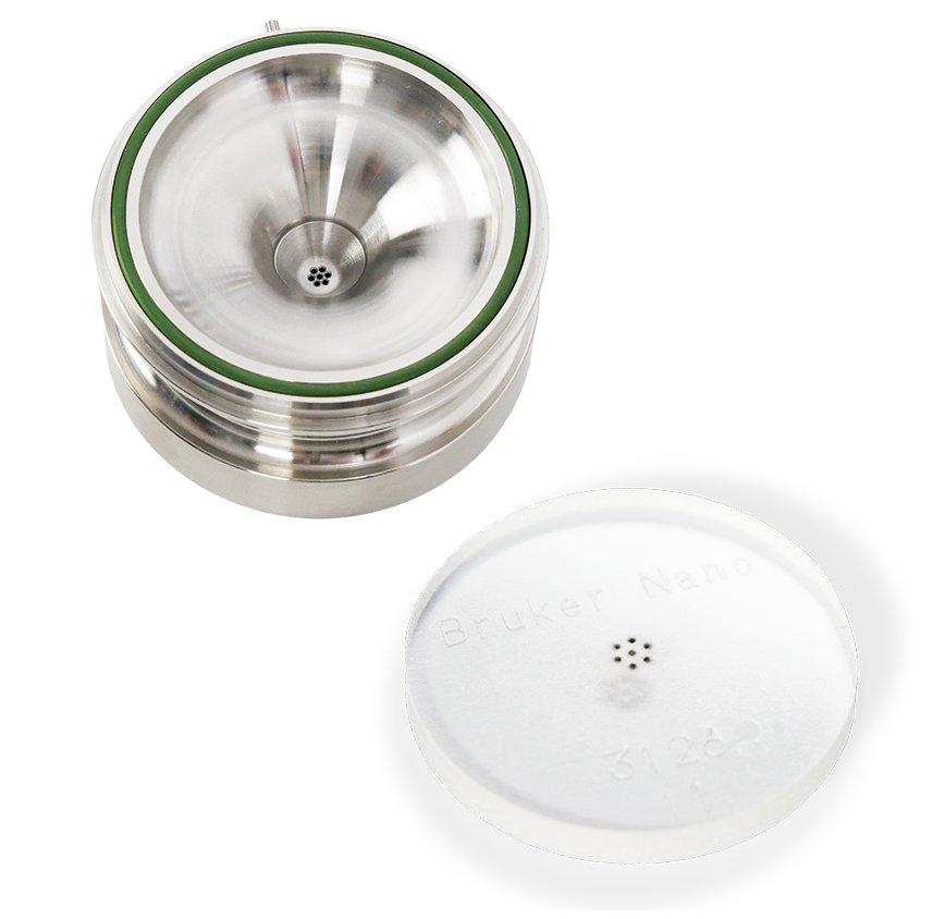 Sample carrier (round metallic object with insides curving towards a filter hole in the center) and fractioning stage (flat white disk with raised edges and filter holes in the center)